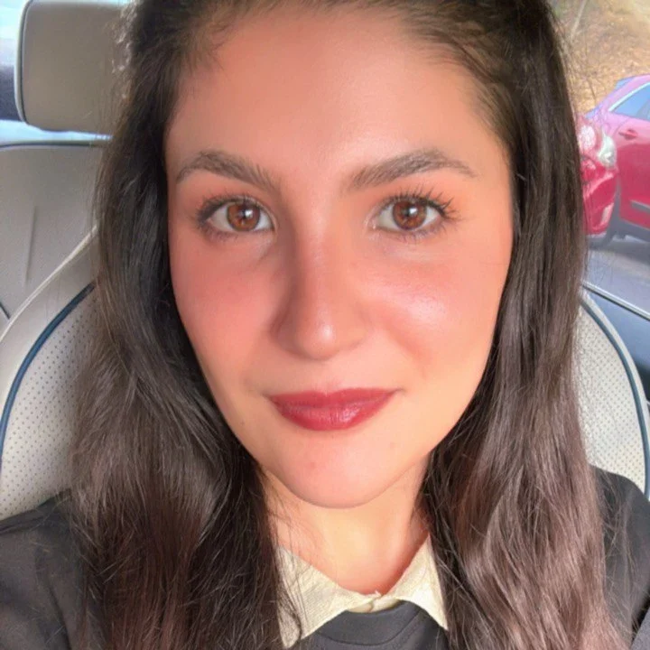 A portrait of Nour, a dietitian and author of the MedDietMindset blog, wearing a red shirt and smiling at the camera.